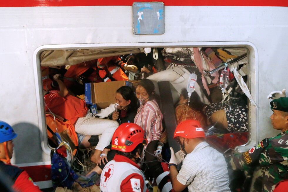 Rescuers trying to reach 3 people trapped in damaged train car after crash in Indonesia